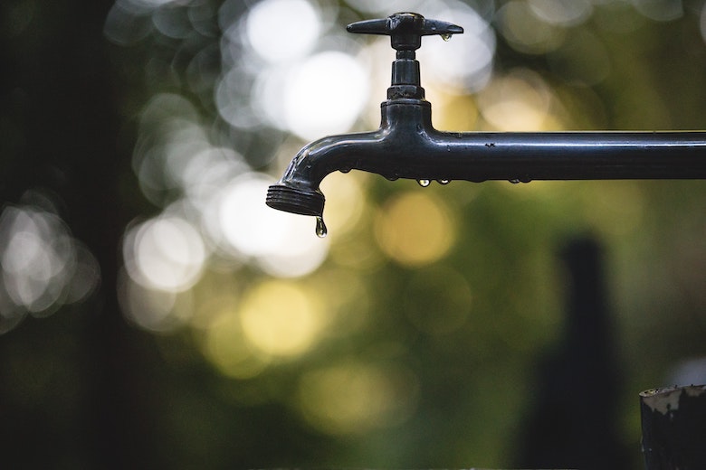 Tropfender Außenwasserhahn als Hinweis auf sparsamen Wasserverbrauch